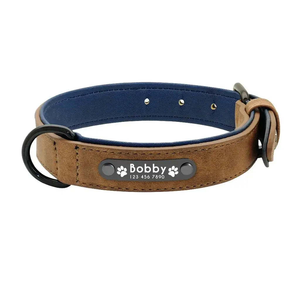 Customized leather dog collar in brown suede with navy blue interior and a black metal nameplate engraved with bobby and paw prints displaying customization information.
