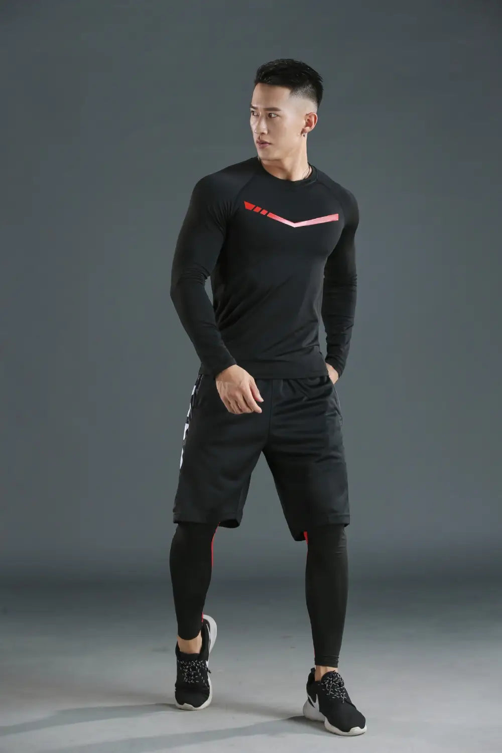 Camiseta térmica de manga larga para hombres, de color negro, con forro polar y logotipo geométrico rosa, diseñada para un rendimiento de secado rápido en un conjunto de ropa interior térmica para hombres.