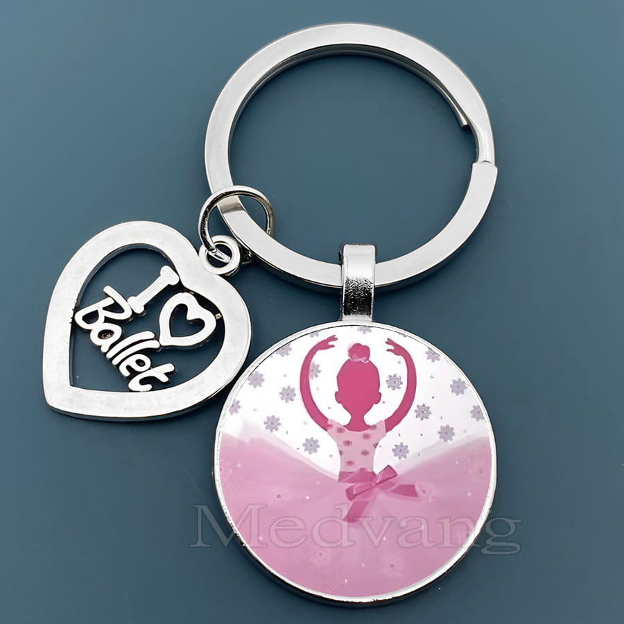 「I heart ballet」と刻印された銀色のハート形チャームと、ラウンドのピンク色ガラスドームのバレエダンサーペンダント。バレエキーチェーンのギフトで、きらめく雪の結晶のディテールが施されています。