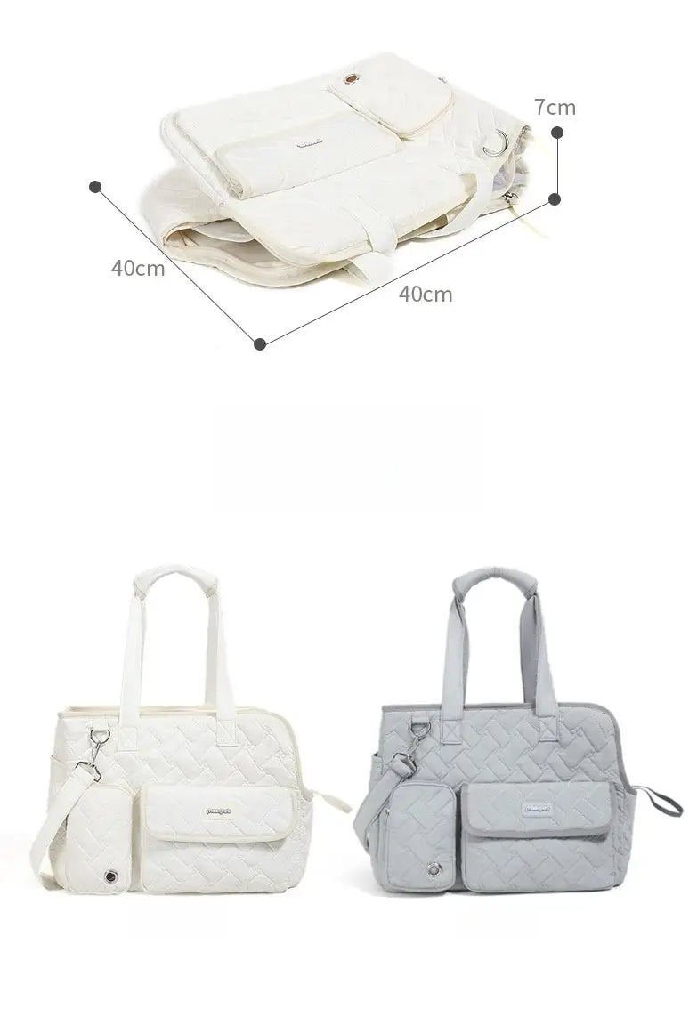 Bolsa transportín acolchada blanca y gris para mascotas, confeccionada en tejido suave, con bolsillos frontales, correa de hombro ajustable y asas superiores para transportar gatos y perros pequeños.