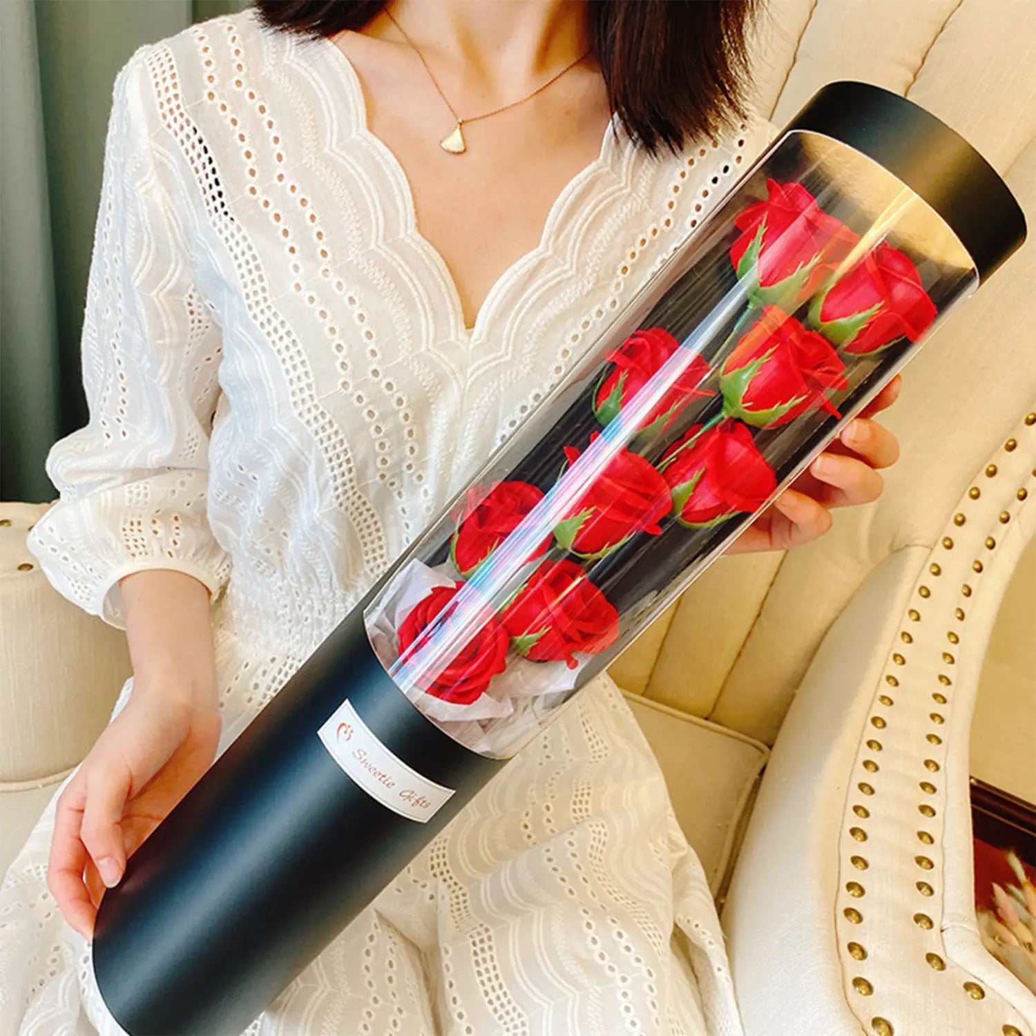 Schwarzer zylindrischer Behälter mit leuchtenden roten LED-Rosen-Seifenblumen in einer Geschenkschachtel für den Valentinstag