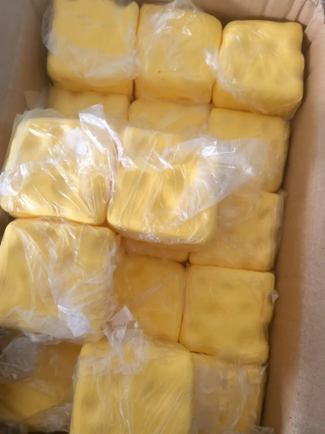 esponjas de juguete blando de descompresión de crecimiento lento con forma de queso amarillo y con forma cuadrada, envueltas individualmente en plástico transparente, vistas desde arriba