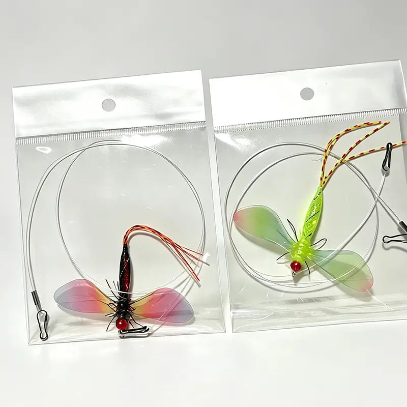 Zwei farbenfrohe durchscheinende Fliegenfischköder mit detaillierten Flügeln und roten Perlenaugen, in klaren Plastiktüten verpackt als farbige Libellen-Cat-Toy-Ersatzkopf-Teile.