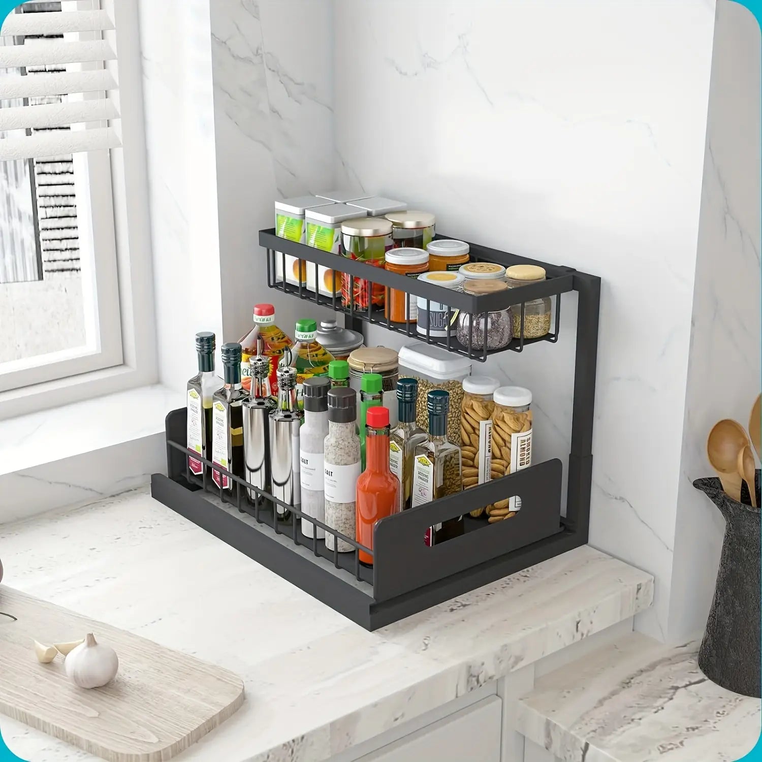 Black metal two-tier spice rack with wire mesh shelves and solid base holding various jars and bottles of condiments as an under sink organizer 2 tier.