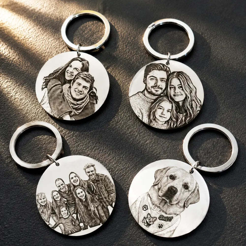 Silver circular stainless steel custom photo keychains featuring engraved black and white portraits of families and a dog.