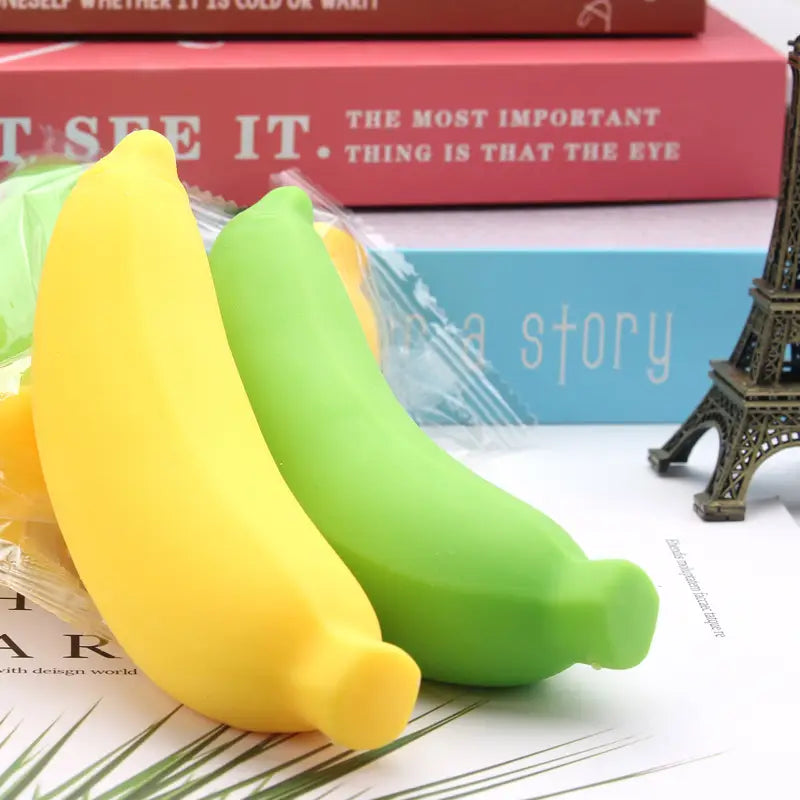 silicone banana slow rising stress relief toys in yellow and green shown from the front angle