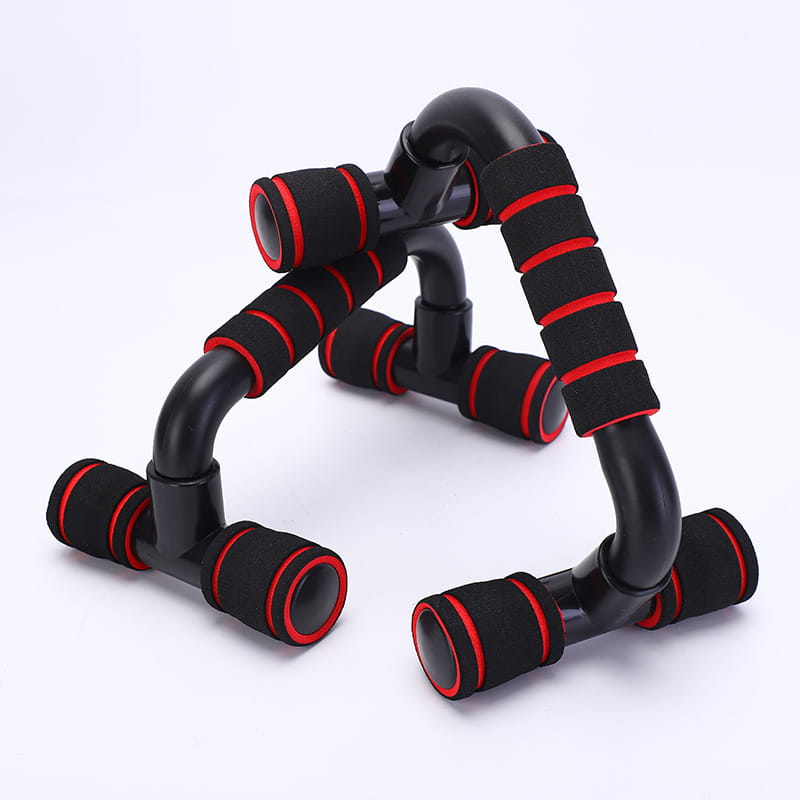 Barras de flexiones en forma de H para entrenamiento de fuerza con empuñaduras de espuma negra y roja y un diseño curvo y moderno.