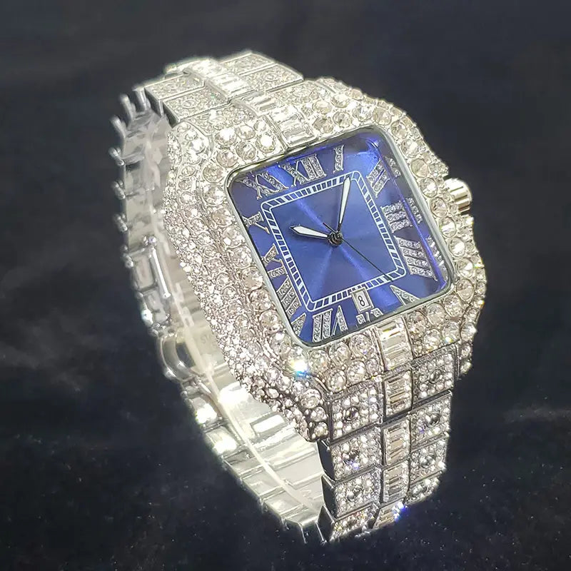 A dazzling iced out diamond square watch for men featuring a deep blue dial with roman numerals and a diamond-encrusted silver-toned metal band.