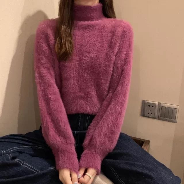 A plush magenta fuzzy turtleneck sweater for women made from warm knit material perfect for winter.