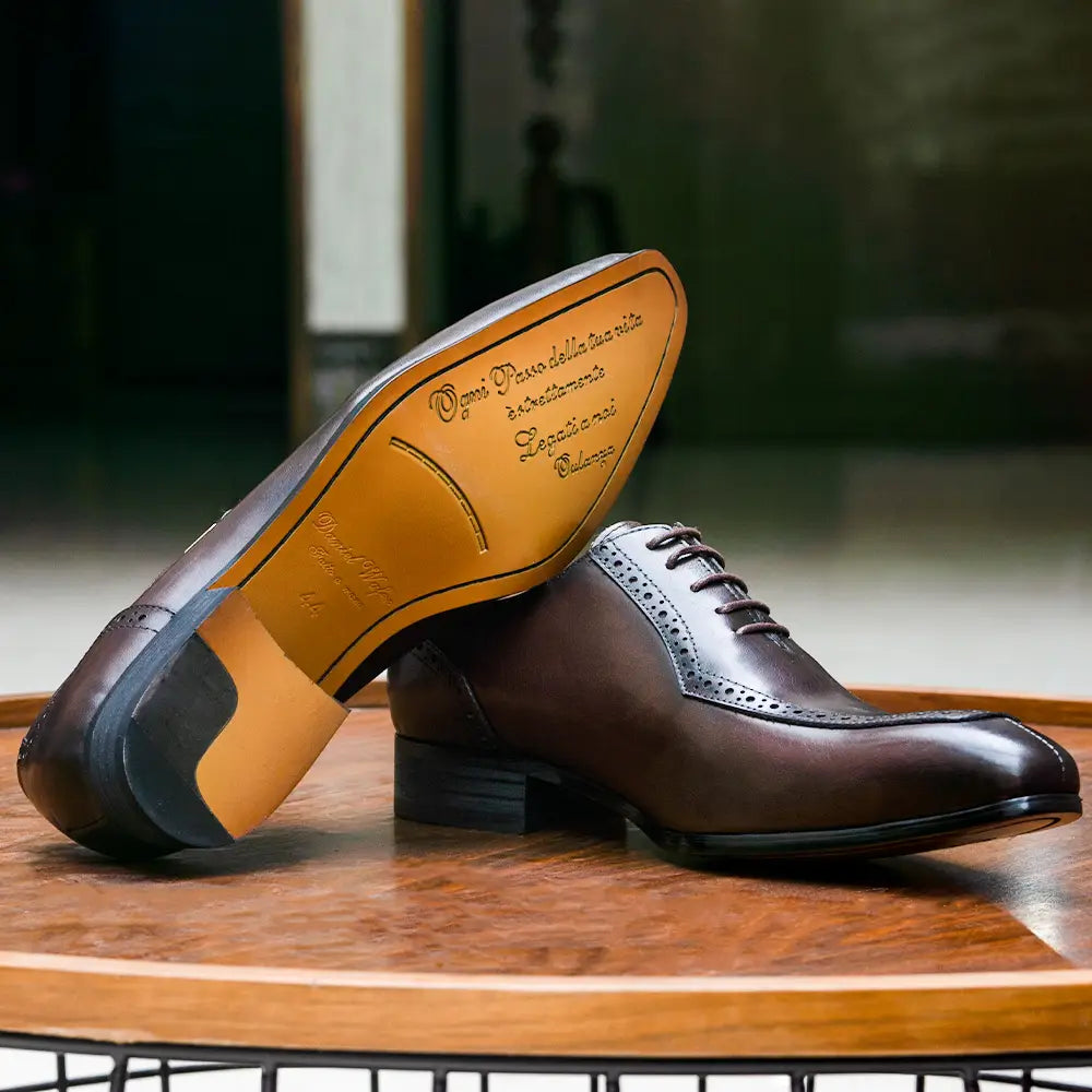 Chaussure de ville à bout brogue type derby Oxford pour homme en cuir véritable marron, avec accents noirs et motif brogue détaillé.