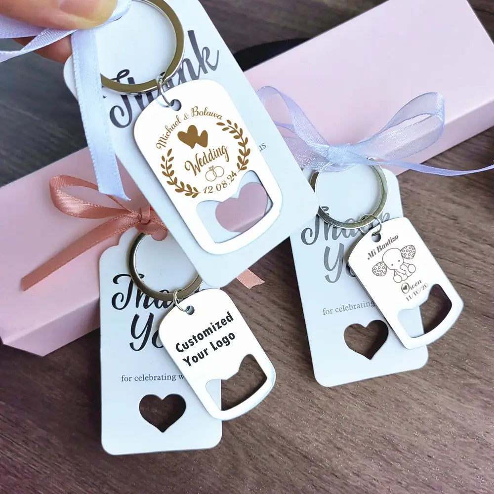 結婚式の詳細が刻印された、ハート型の切り抜きを備えたホワイトの金属製キーチェーンボトルオープナー（結婚式の引き出物向け）。