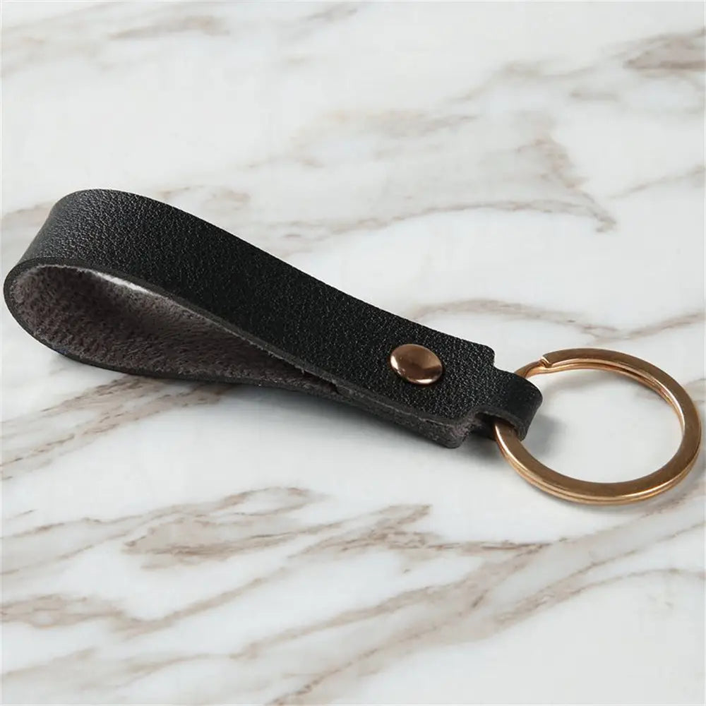 Black leather pu leather keychain with a gold-toned metal keyring and a single brass-colored rivet for fashion and functionality.