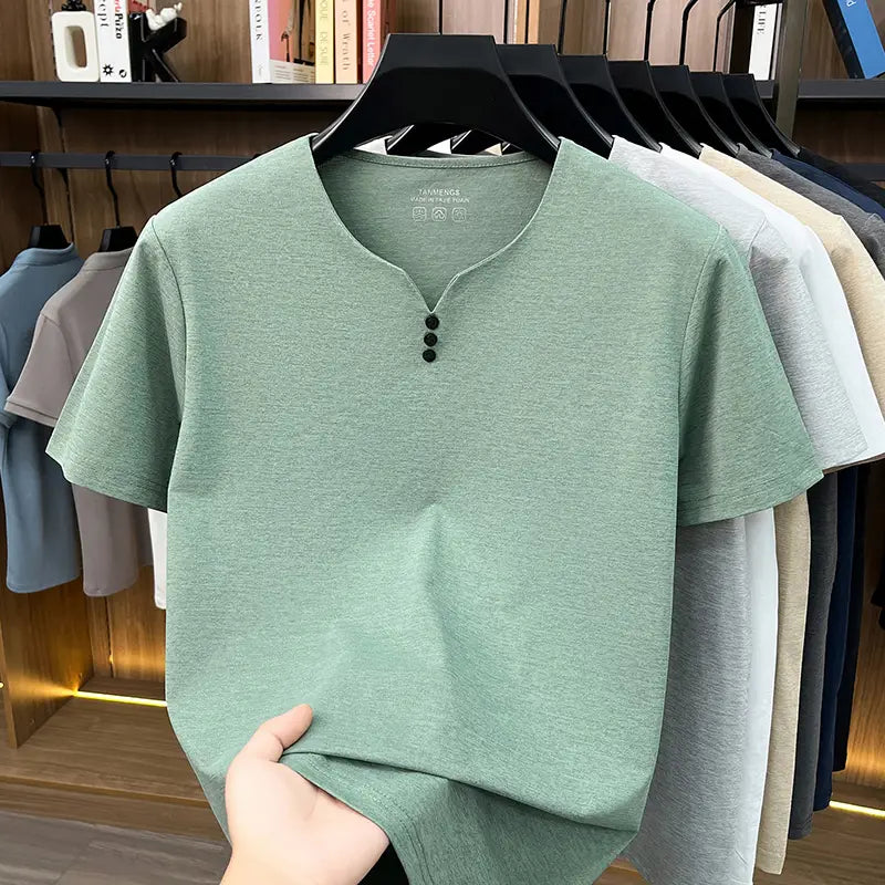 Una camisa tipo henley para hombre de manga corta color verde menta suave, con una textura jaspeada sutil y tres cierres con botón negro en el cuello, diseñada como camiseta informal tipo henley con textura.
