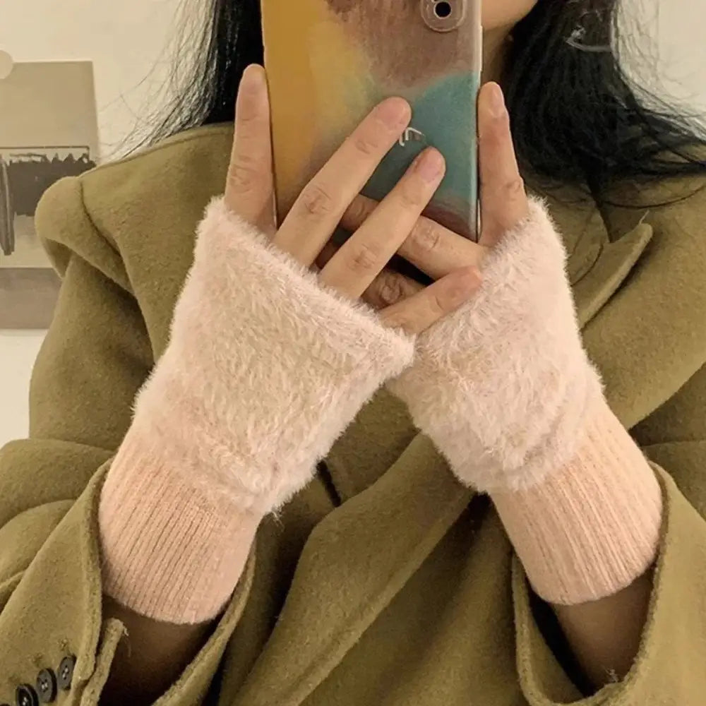 Soft pink fluffy fingerless knit gloves made of fuzzy material with a ribbed knit cuff.