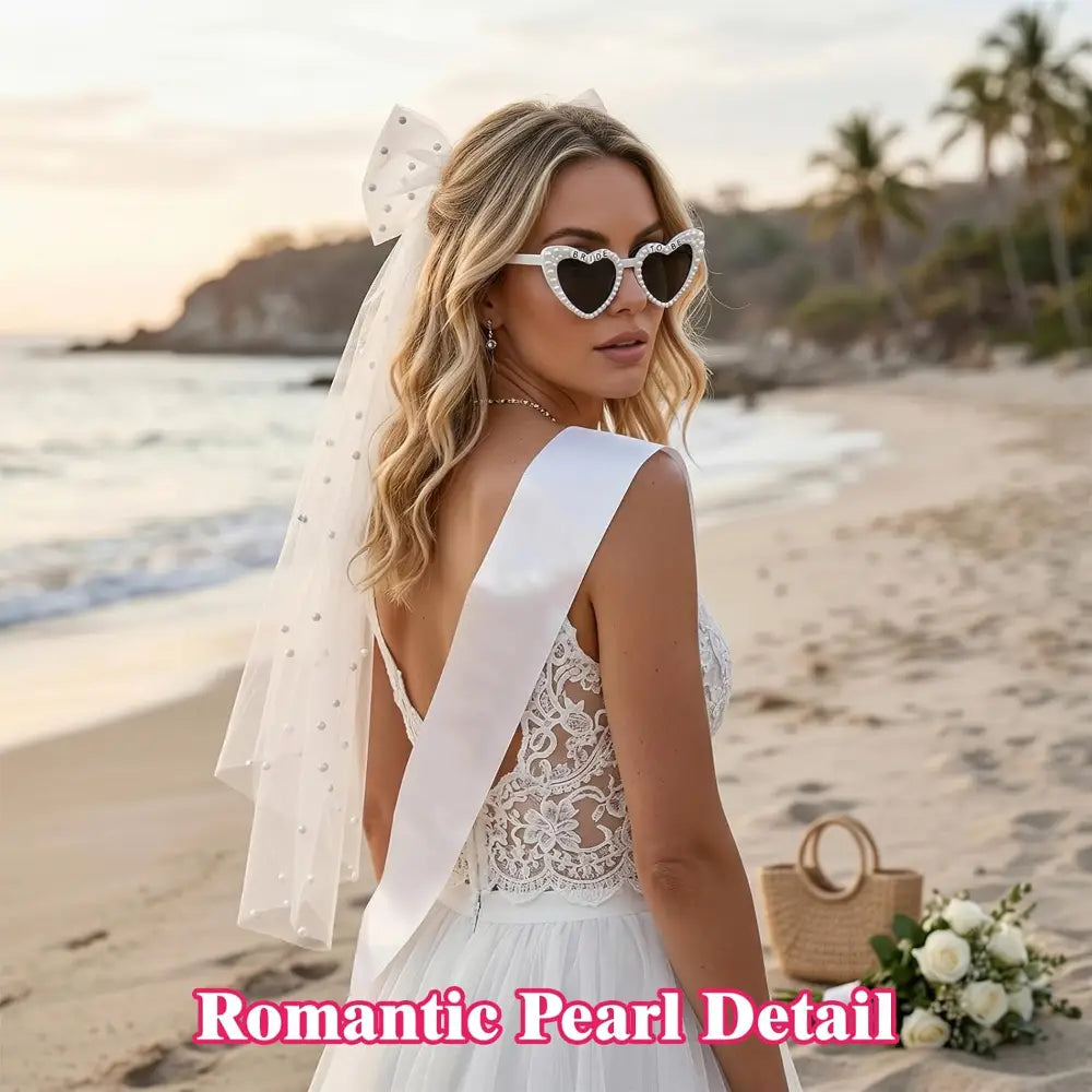 Gafas de sol con forma de corazón en blanco, con detalles de pedrería brillante, de una futura novia; conjunto de accesorio con velo y faja.