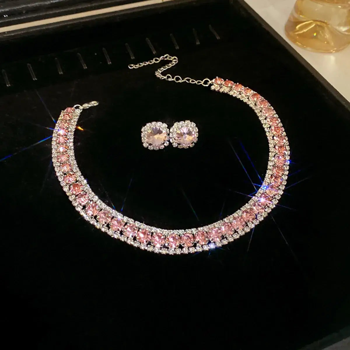 A sparkling pink and silver rhinestone crystal necklace and earring set featuring a double row of faceted stones in a sleek metallic frame for wedding jewelry.