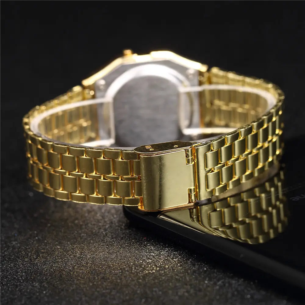 Des hommes ont conduit une montre numérique avec un bracelet de montre-bracelet en acier inoxydable à tons dorés, présentant un design poli d’éléments à maillons emboîtés.