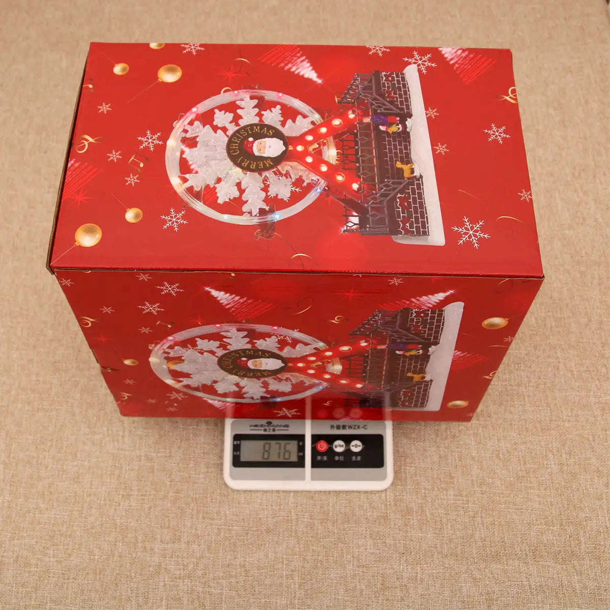 Boîte-cadeau rouge à thème de Noël avec des flocons de neige du père Noël et des ornements dorés pour l’emballage de l’ornement de manège forain musical de Noël