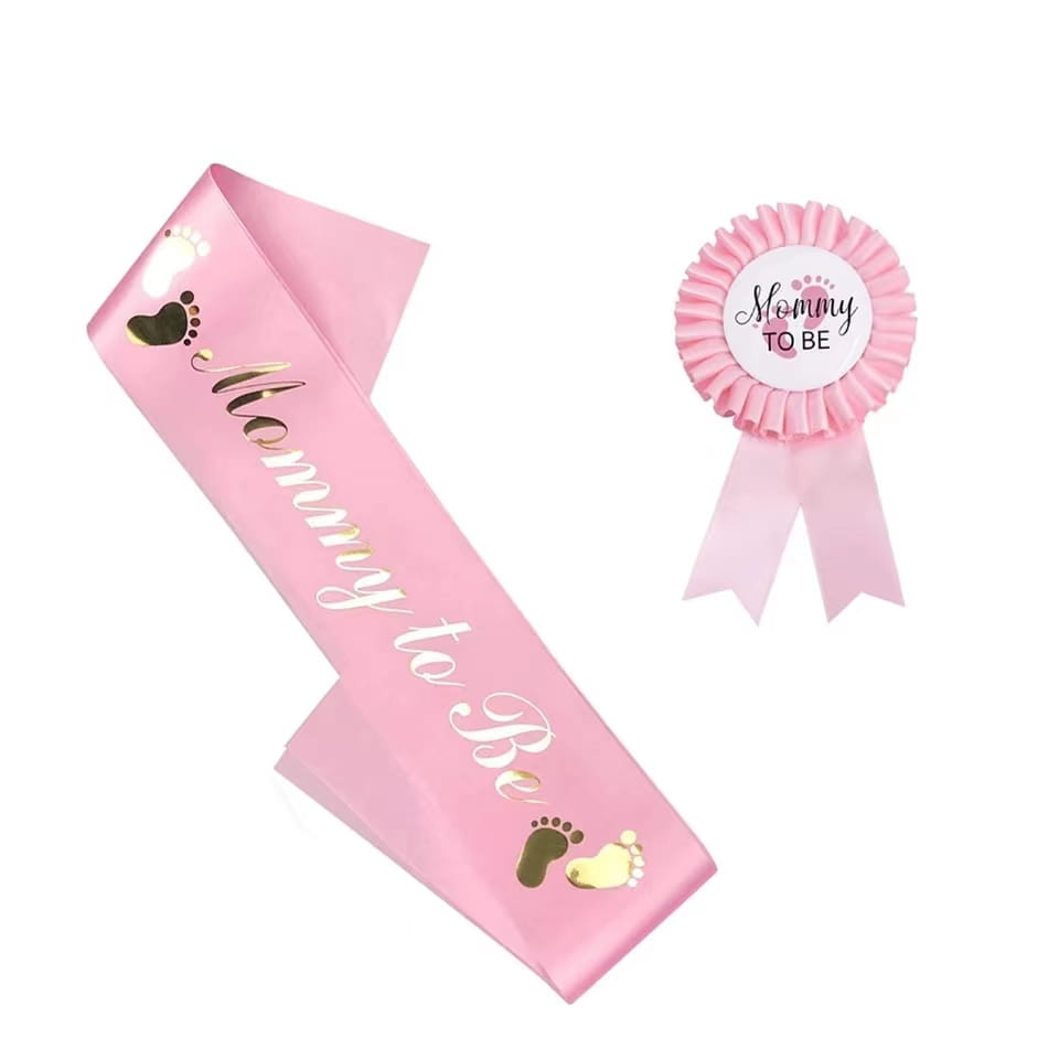 Écharpe « Pink mom to be » pour maman avec empreintes en feuille d’or et lettrage blanc en cursive, faisant partie d’un kit de révélation du sexe pour écharpe et badge.