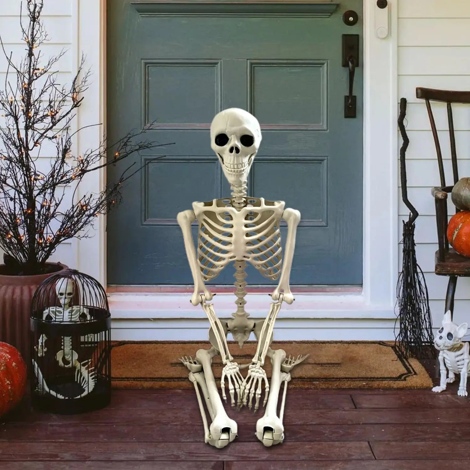 una figurita de esqueleto de Halloween de plástico blanco, sentada erguida en un porche como decoración posable para exhibiciones de casas encantadas.