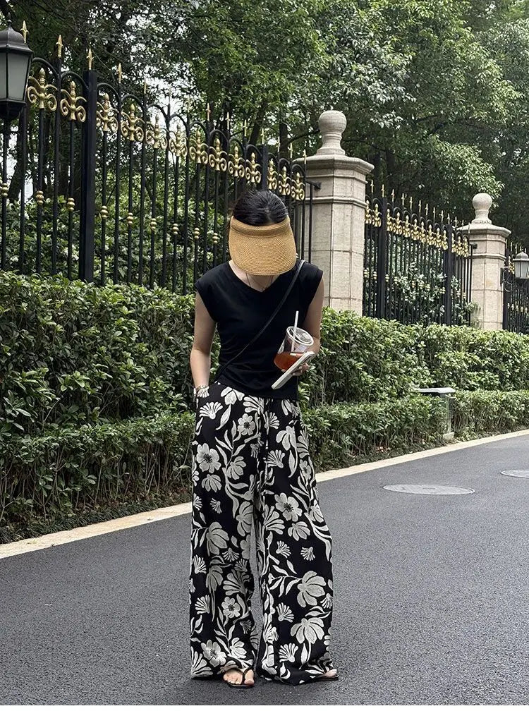 pantalons à jambes évasées noir et blanc à imprimé floral pour femmes, offrant une coupe confortable à jambes évasées et un tissu léger adapté à un usage décontracté