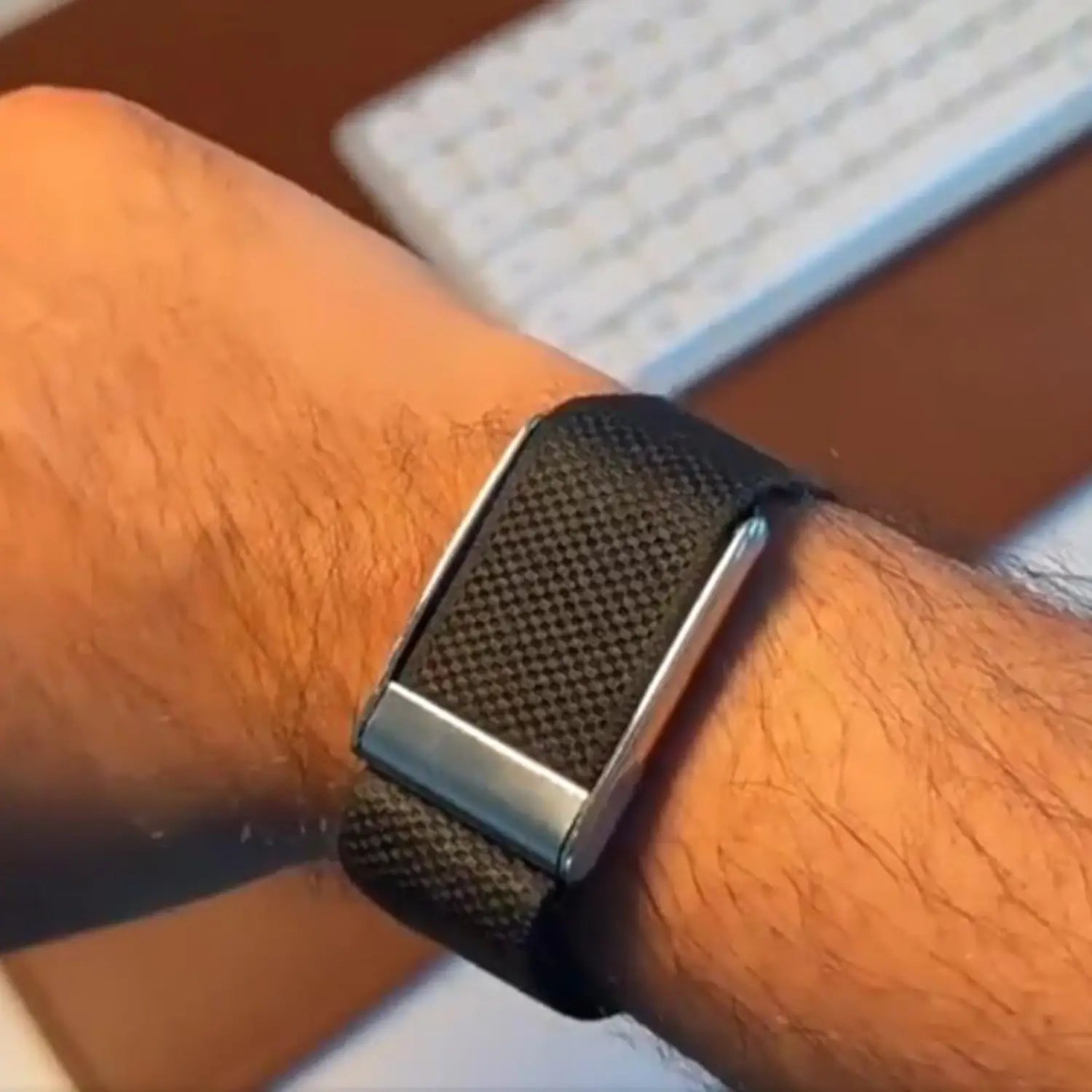 black textured band with silver-toned metal clasp worn on wrist featuring adapter bracket frame for fitbit air to whoop 5.0 integration