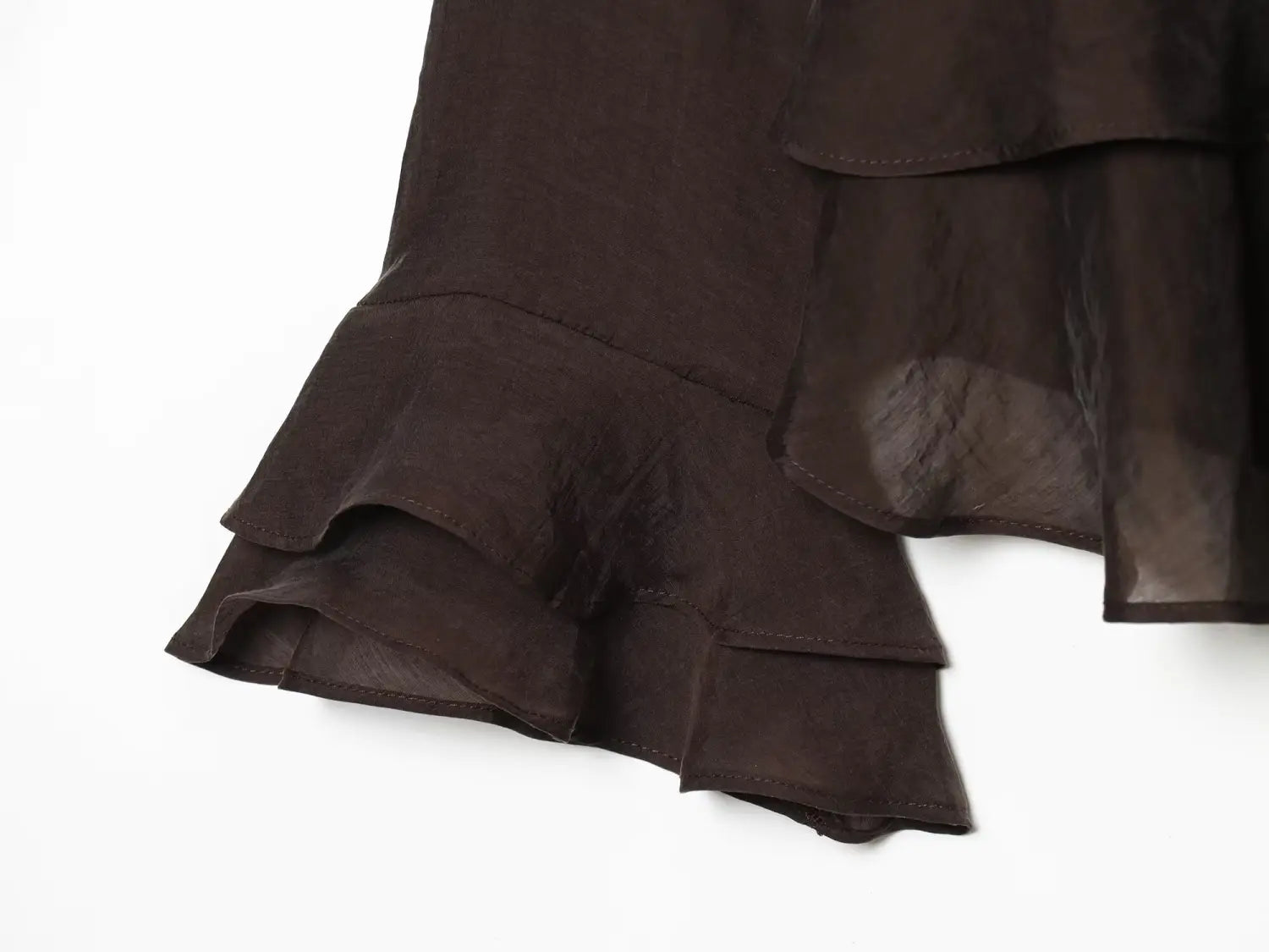 dark brown layered ruffle skirt hem made of lightweight fabric shown with brown chiffon flare sleeve blouse highlighting sleeve style details