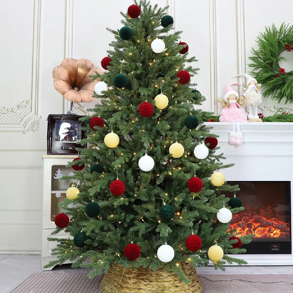 Ein festlicher grüner Weihnachtsbaum, der mit Christbaumkugeln in Samtoptik in Rot, Weiß und Gelb mit strukturierten Ornamenten aus der grünen Sortimentsauswahl, 12-teilige Packung, geschmückt ist.