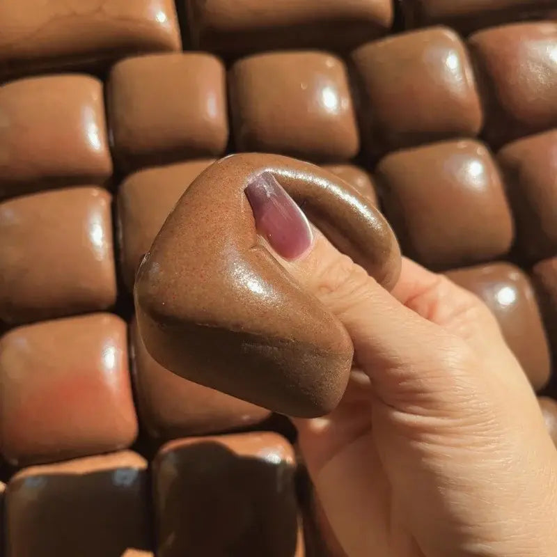 a glossy square-shaped chocolate candy miniature in rich brown color featured as a slow rising squishy mini toast fidget toy.