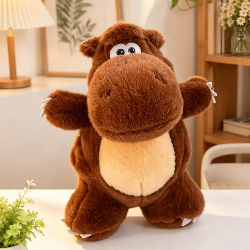 Jouet peluche de hippopotame brun avec un ventre de couleur crème et des griffes blanches, en tant qu’animal en peluche souple, dans la collection de peluches de dinosaure colorées.