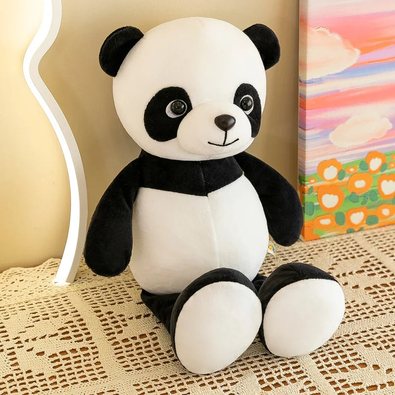 Un peluche de animal de la jungla que presenta una muñeca de panda suave en negro y blanco, con facciones redondeadas y ojos bordados.