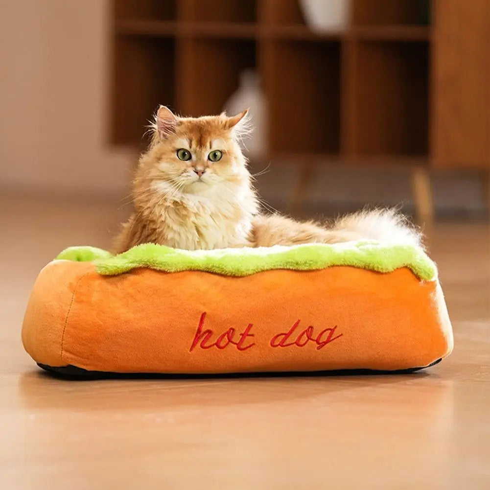 Orangefarbener Plüsch-Hot-Dog-förmiger Hundebett mit grünem Salat-Rand aus Kunstfaser und rotem besticktem Text, entworfen als Ruheplatz für kleine Hunde.