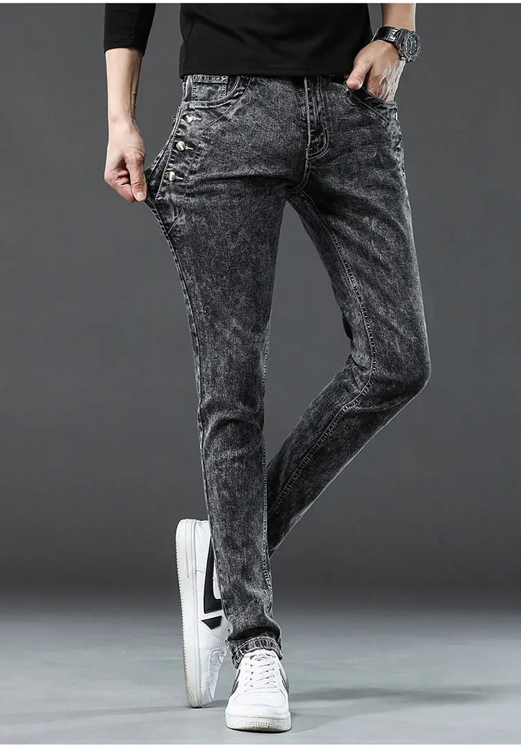 Jeans en denim extensible vintage slim pour hommes, gris foncé, avec texture délavée et usée, et détails de surpiqûres visibles.