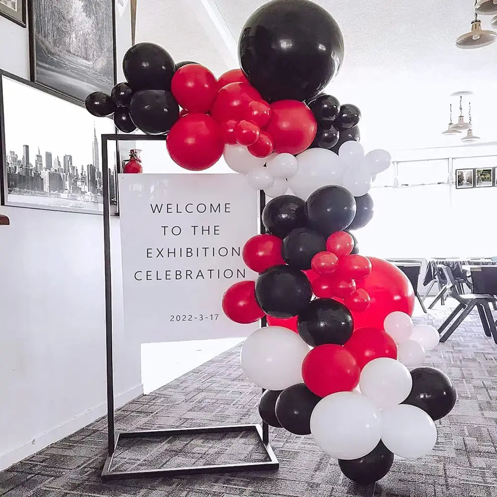 Eine lebendige Partydekoration „Rot Schwarz Weiß Ballon-Set“ mit einer herabfallenden Bogenform aus glänzenden Latexluftballons.