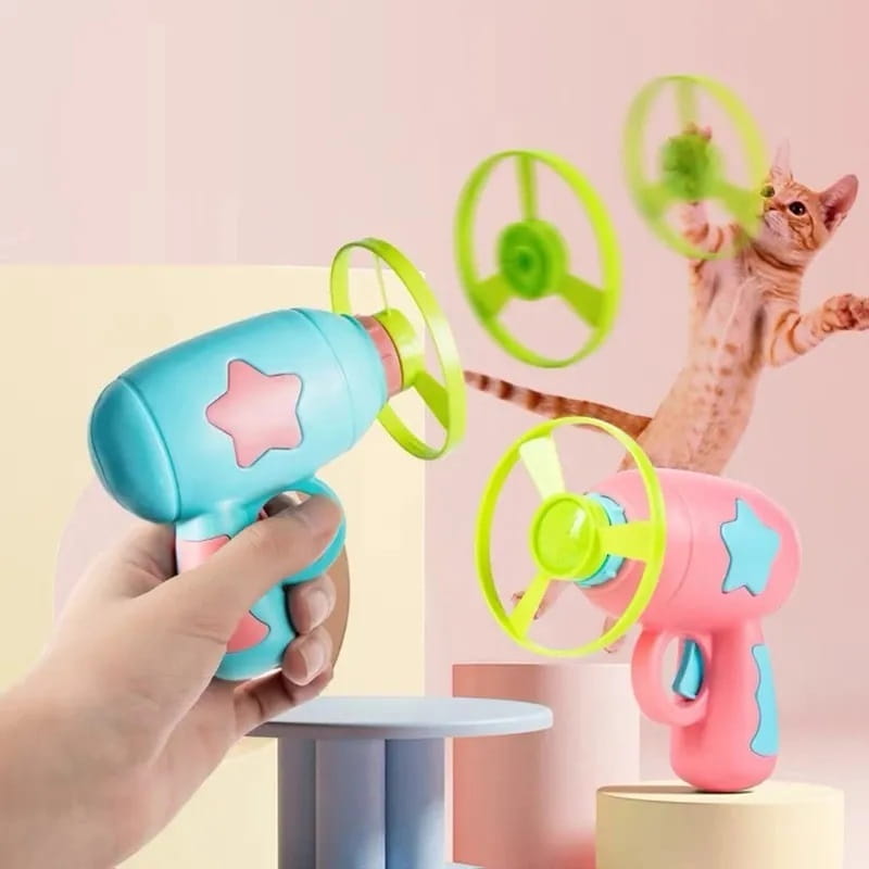 ターコイズ色とピンク色のプラスチックで作られ、星形のデザインと緑色の回転ディスクを備えたインタラクティブ飛行ディスクの猫用おもちゃの銃。