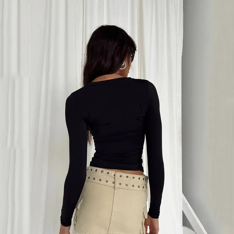 Blusa corta ajustada tipo slim fit negra para mujer, con mangas largas fruncidas, cuello redondo y cintura ajustada, diseñada para mujeres.