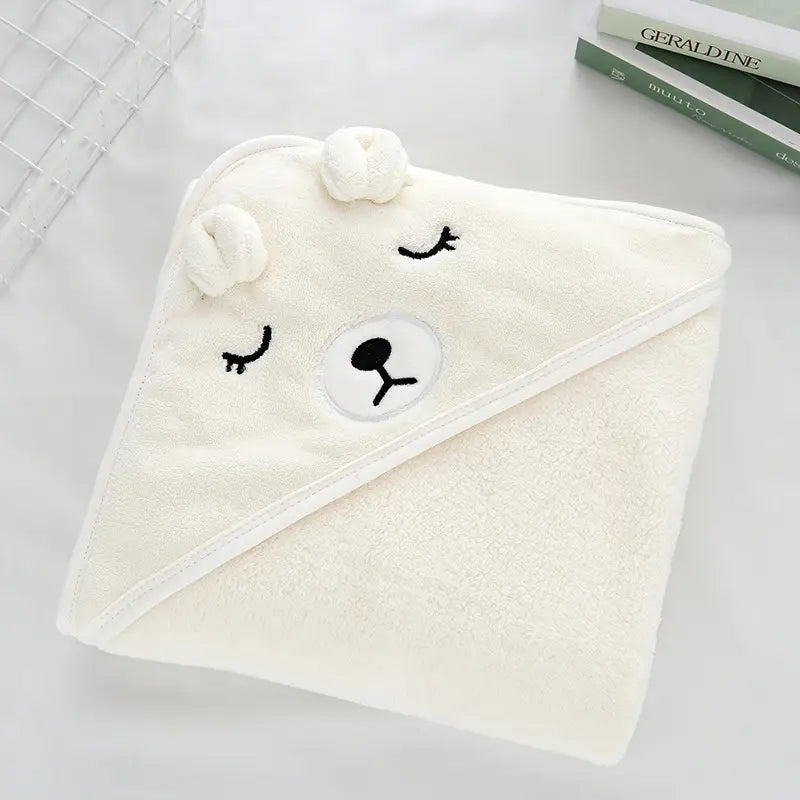 Ein weicher, cremeweißer Plüsch-Bademantel und ein Handtuch für Babys mit Kapuze, mit einem niedlichen Bären-Gesicht, bestickten geschlossenen Augen und einem runden Nasenpatch.