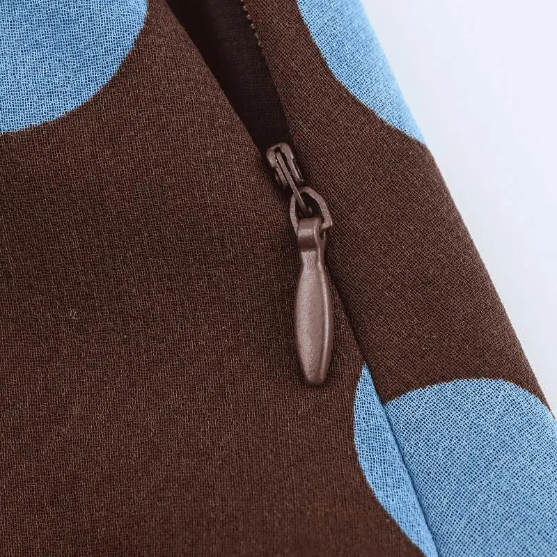 Braune Stofftasche mit hellblauen Kreis-Mustern und dunkelbraunem Reißverschlussgriff, passend zum Damen-Set aus Polka-Dot-Midi-Rock mit Wickelkragen aus Chiffon in ausgewählter Größe