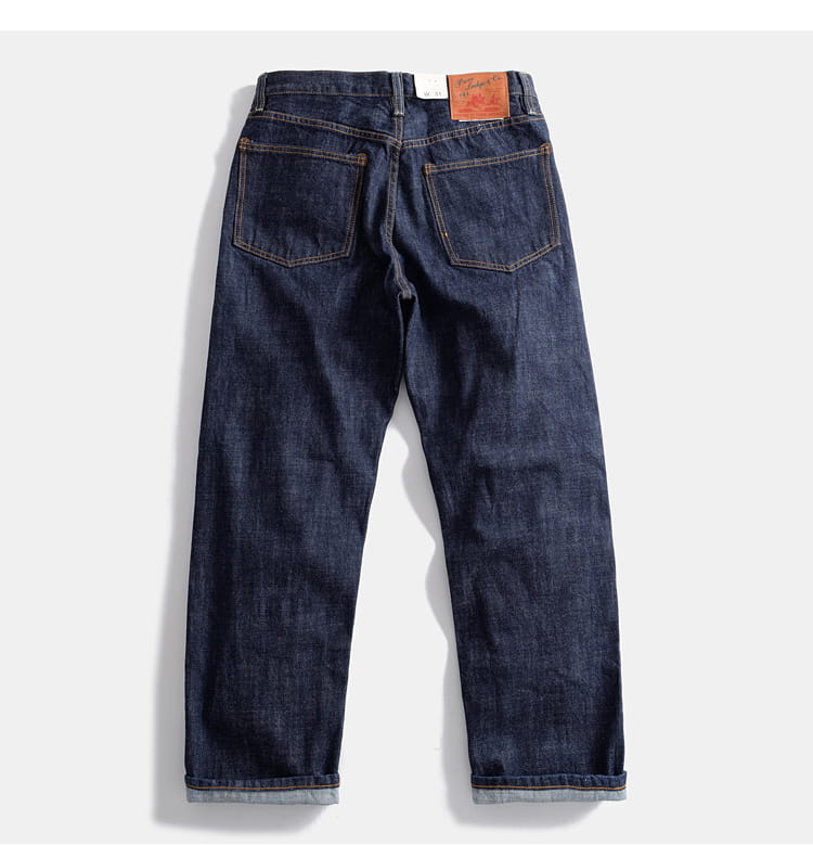 Heavyweight red selvedge denim jeans in dark indigo with classic five-pocket design and rolled cuffs.
