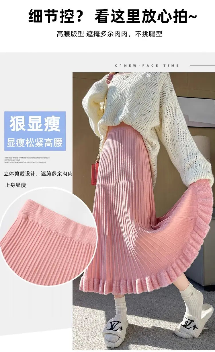 Jupe mi-longue en maille rose, avec texture côtelée, plis à taille haute et ourlet parapluie évasé.
