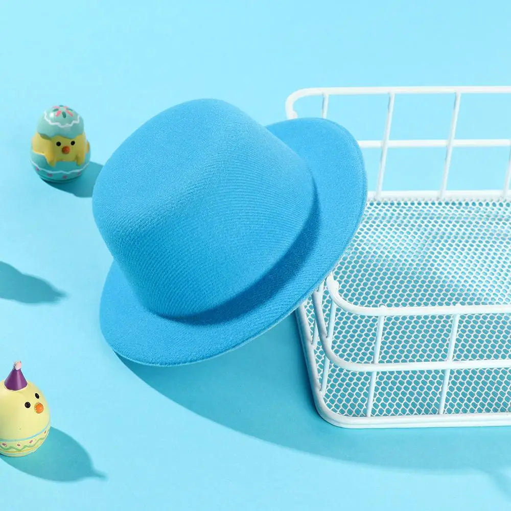 Un chapeau melon (bowler) en feutre bleu clair doux, avec une surface légèrement texturée et une calotte arrondie, conçu comme accessoire de mode pour chapeau de poupée en peluche pour des poupées de 60 cm.