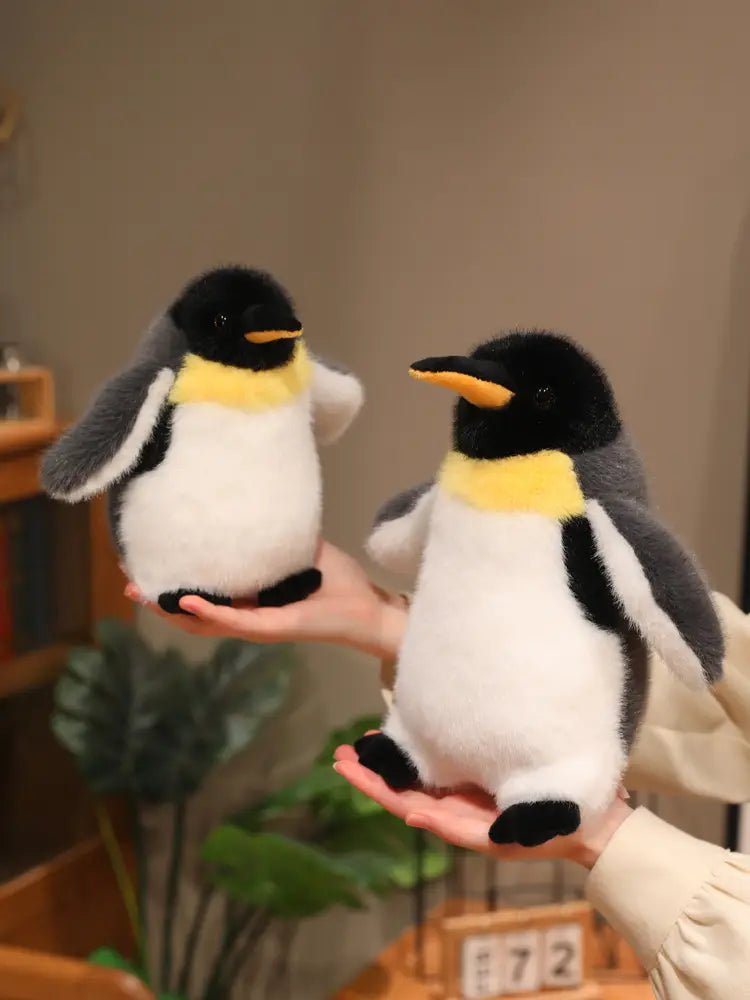 plush emperor penguin stuffed animal soft toy pair featuring black white and yellow fur made of soft plush material.