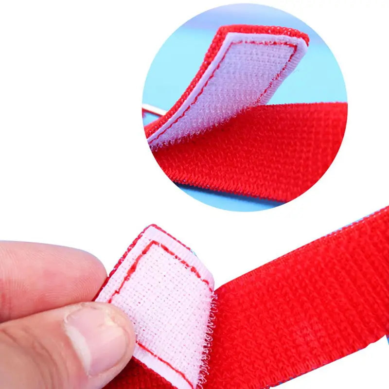 Red velcro strap with white stitched edges and textured surface for securing components in the shaking swing balls party game set.