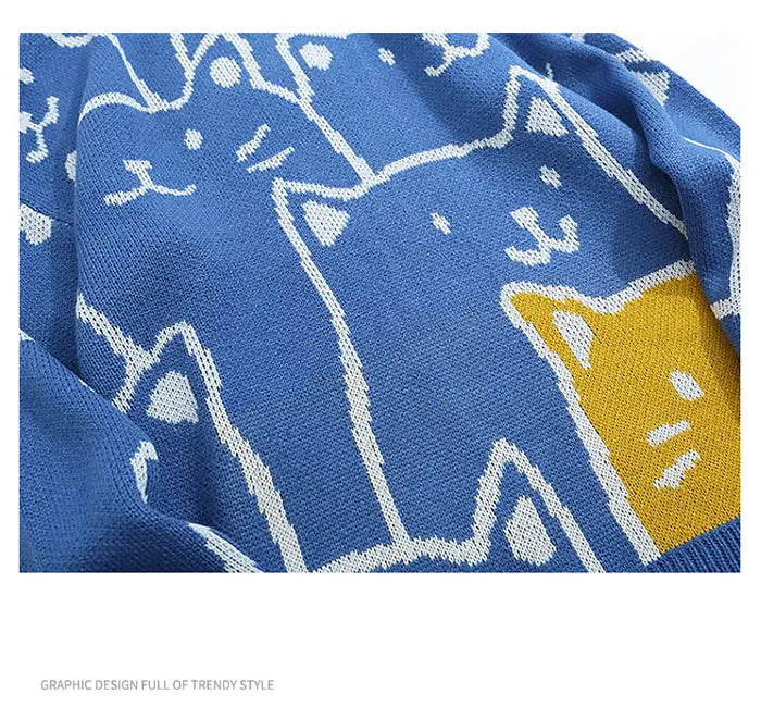Pull ample en maille bleue à motif de chat de dessin animé Harajuku, avec une création graphique ludique de chats de dessin aux contours blancs et jaunes.