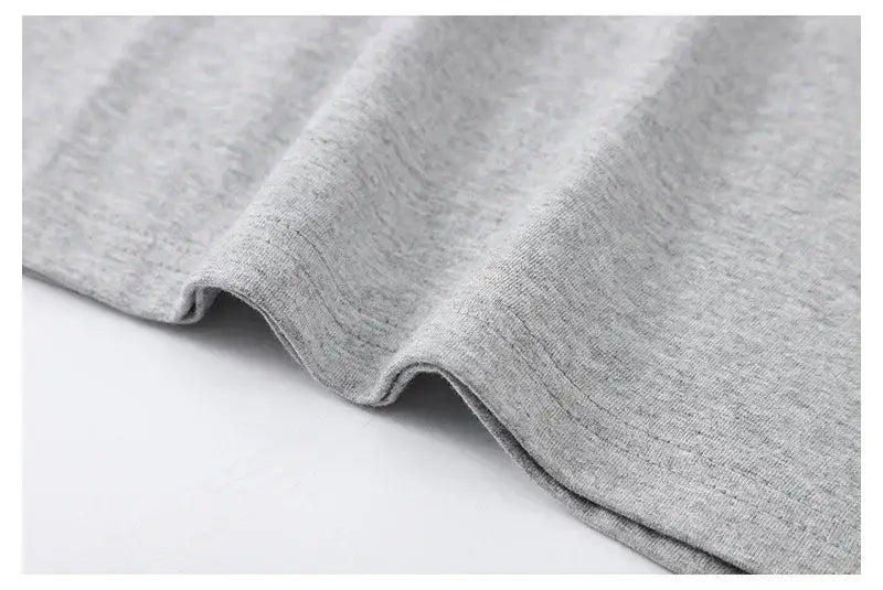T-shirt vintage à motif de voiture de muscle fabriqué en tissu en coton chiné gris clair, doux, présentant une texture subtile et des plis délicats.