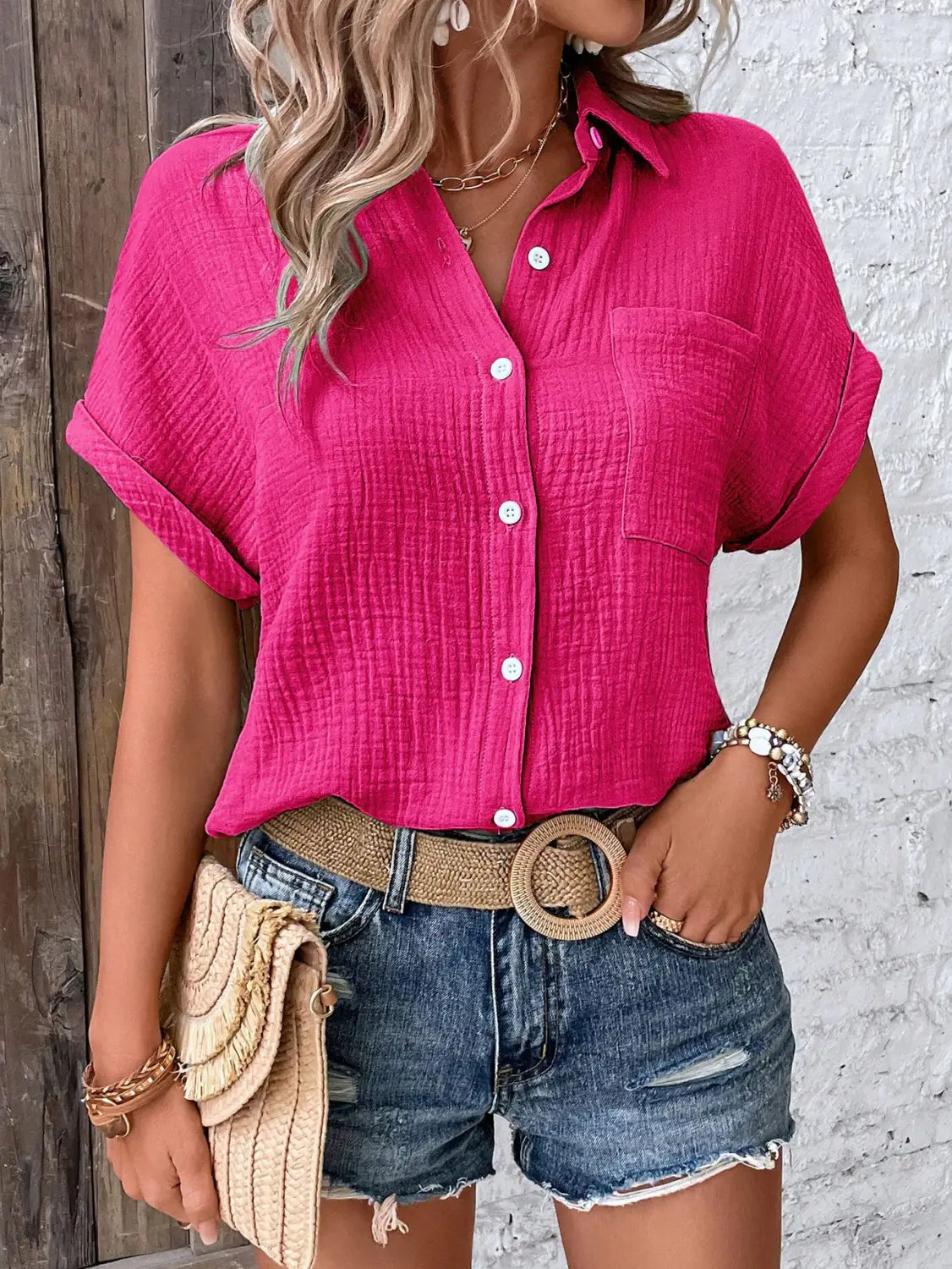 Women cotton short sleeve button up shirt in vibrant pink with textured fabric and rolled cuffs.