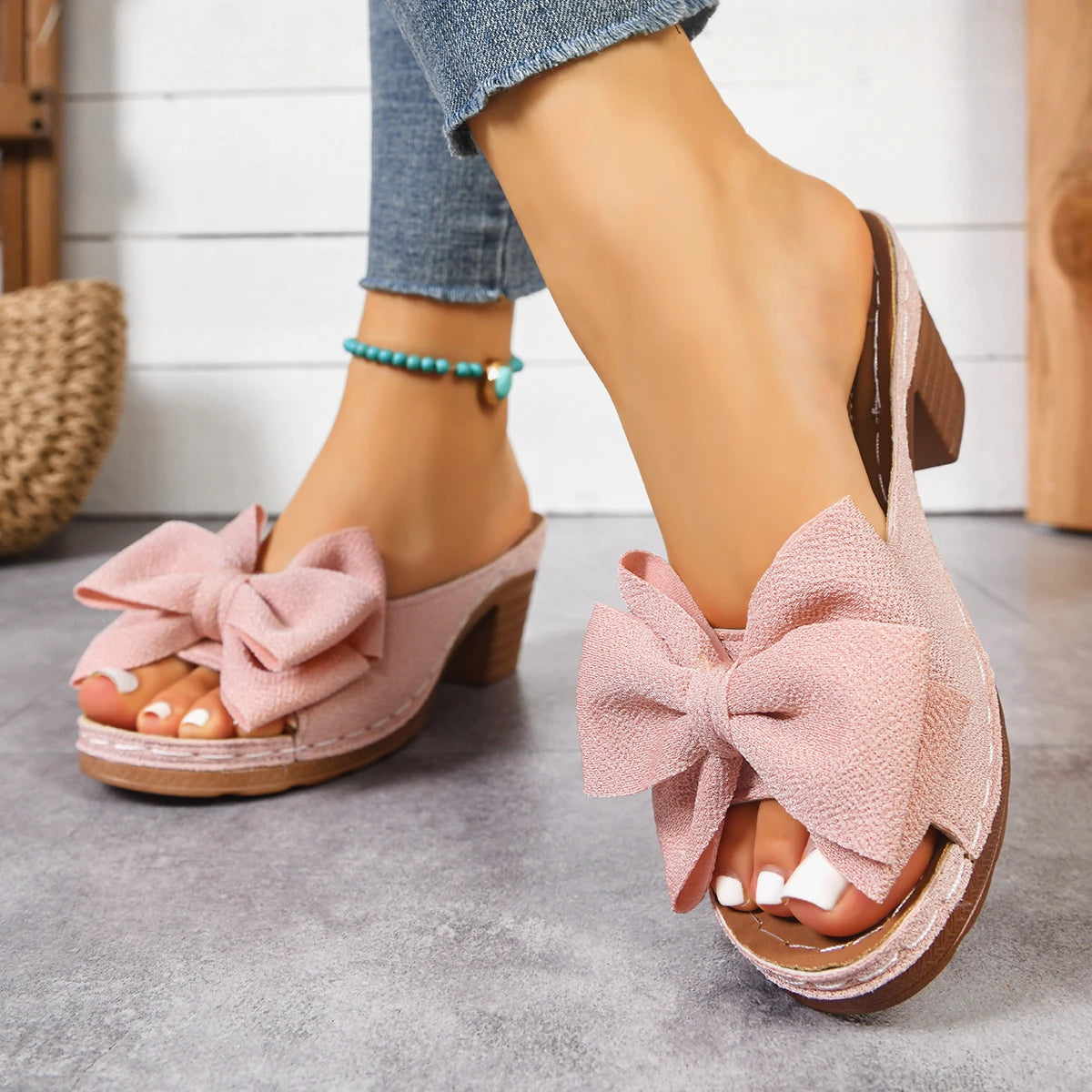 pink suede bow platform mules block heel sandals displayed from the back side.