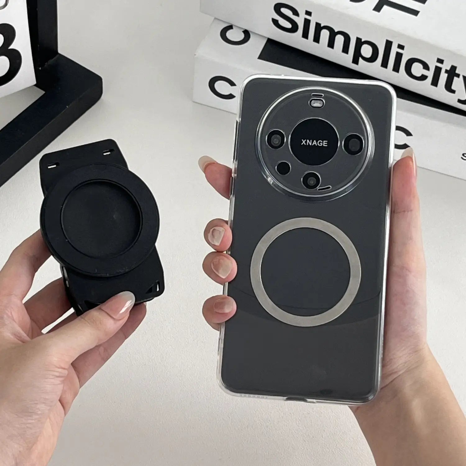 Schwarze magnetische Telefonhülle mit kreisförmigem silbernem Akzentring und Xnage-Branding am Kameramodul, dargestellt von der Rückseite, ausgelegt für die magnetische Telefon-Rucksackclip Universalhalterung.