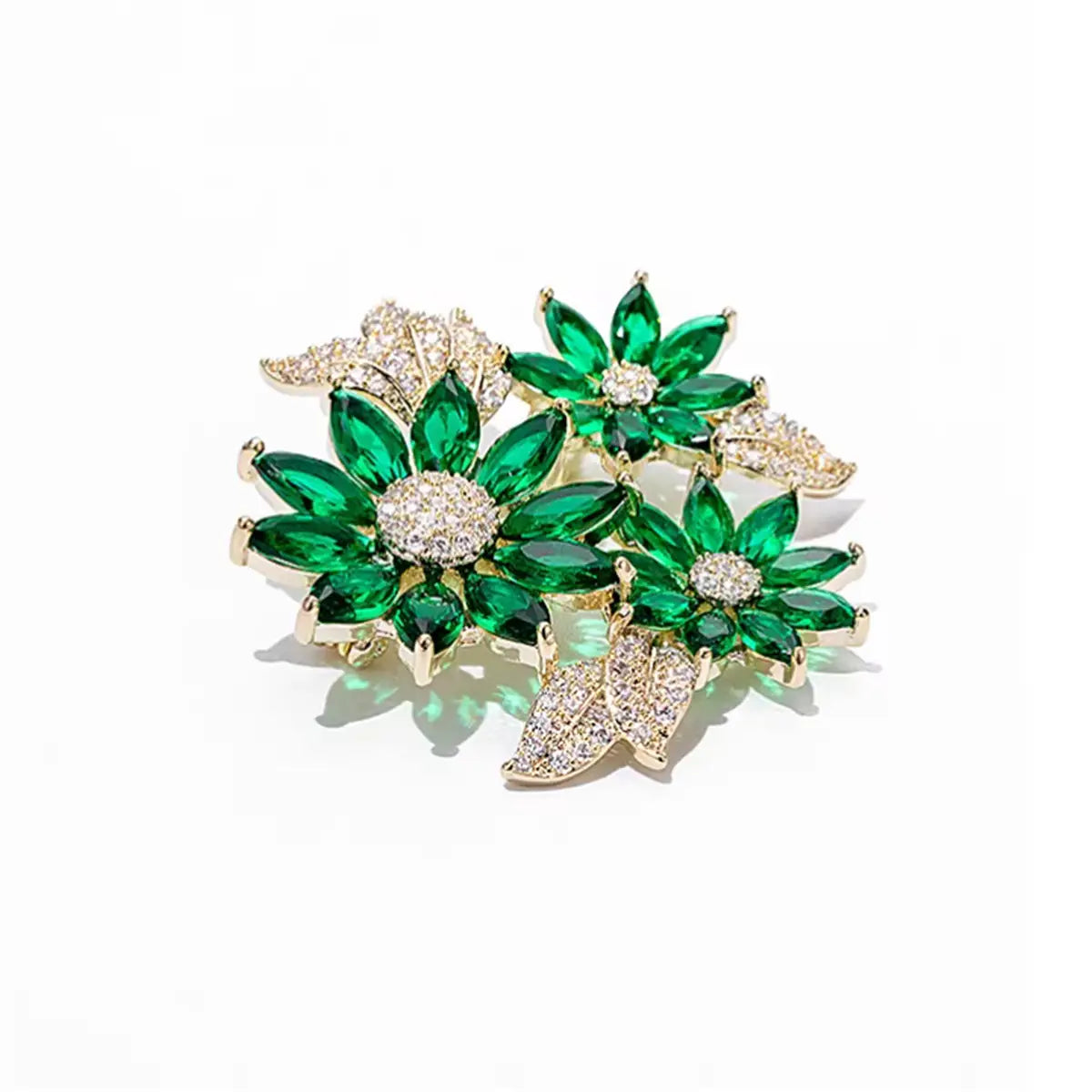 A sparkling green and gold floral brooch pin adorned with emerald-cut crystals and pave-set diamonds.