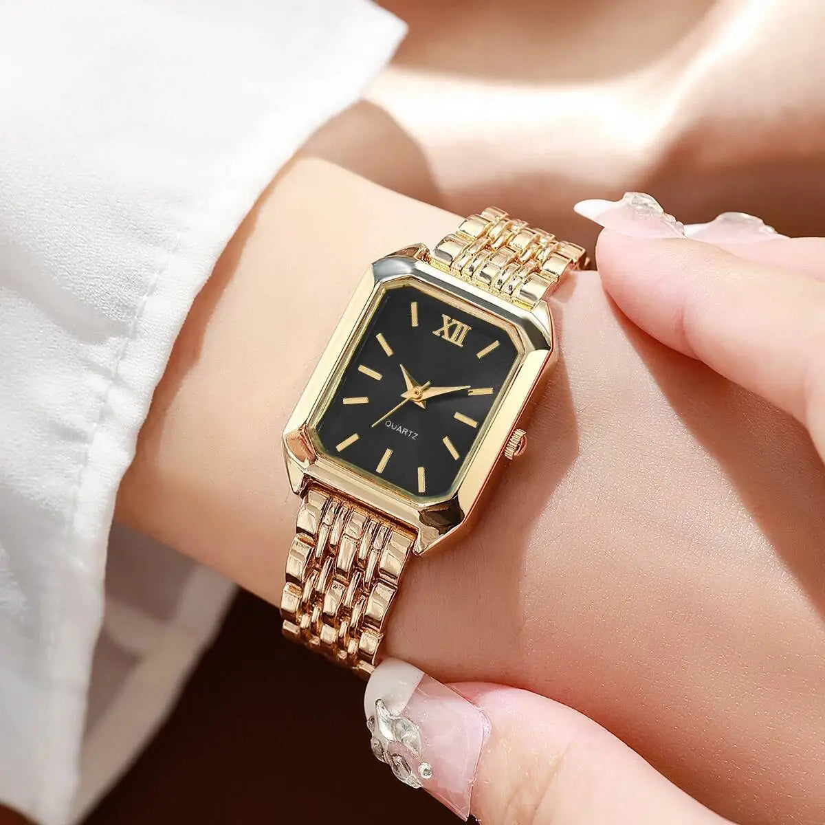 Women gold rectangle quartz watch with a black dial, roman numeral hour markers, and an elegant gold-toned mesh strap.